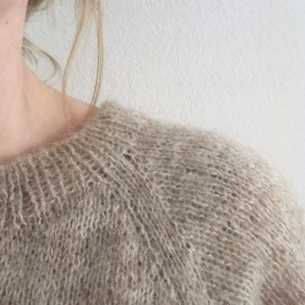 Raglan-detajle. Bred raglanstribe med 4 masker i Evighedscardigan. En cardigan strikket i børstet alpaca fra AlmaKnit.