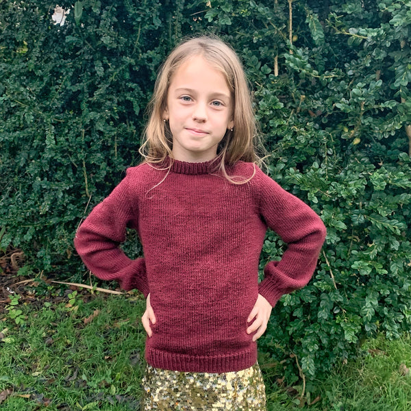 Striksweater til børn. Sandness klompelompe i farven dyb julerød, perfekt julsweater